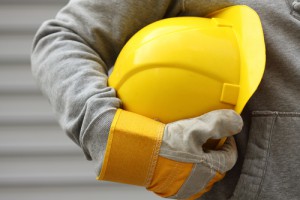 ヘルメットを小脇にはさむ作業員の写真